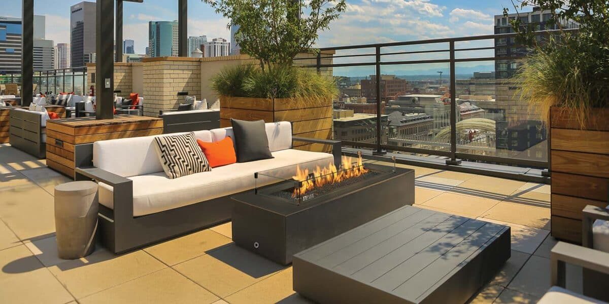 Outdoor gas fireplace on a patio at dusk