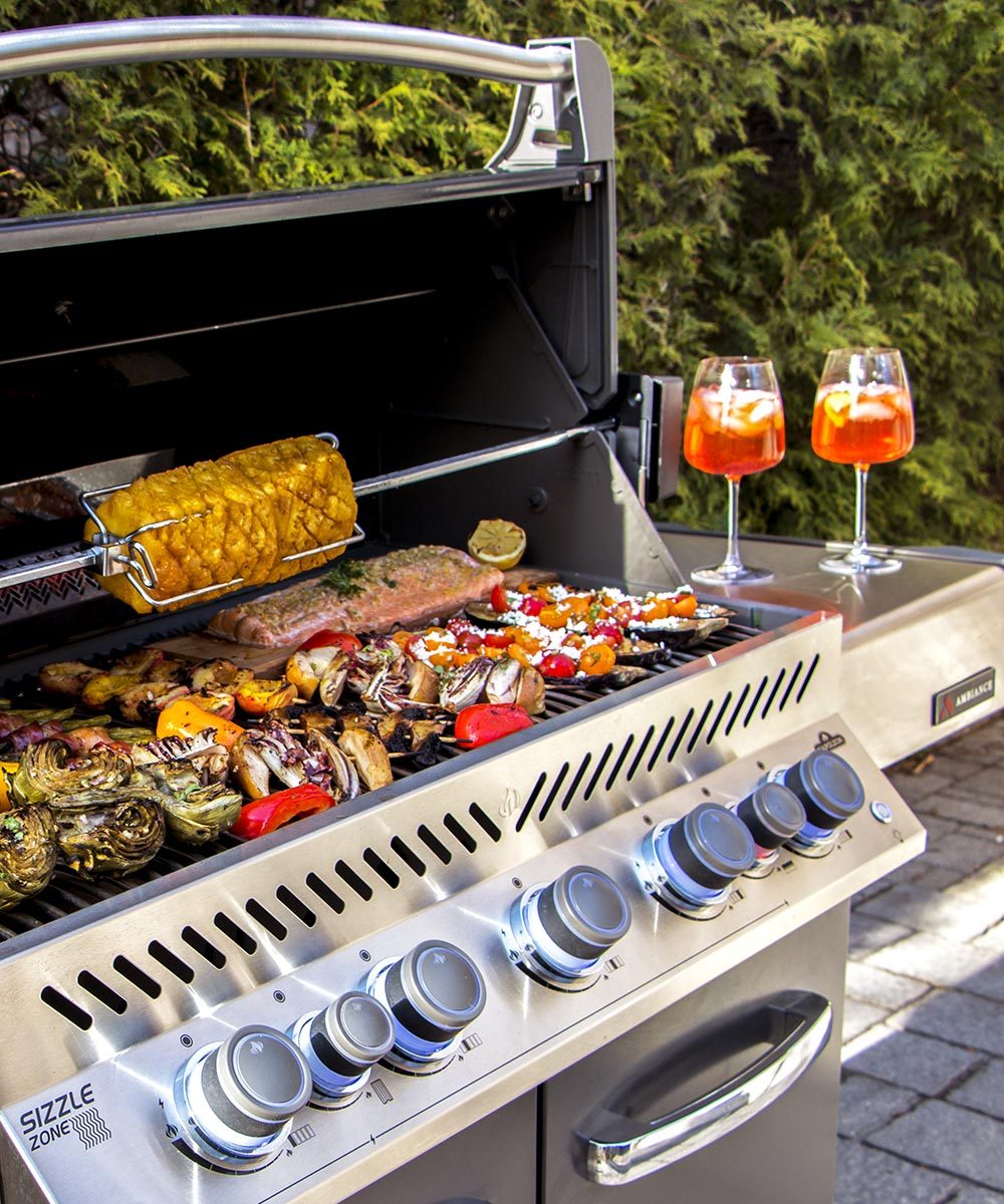 Gas grill loaded with food in an outdoor kitchen
