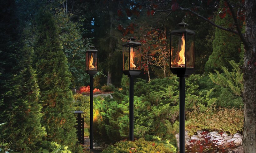 Tempest gas torches lighting a garden path at dusk